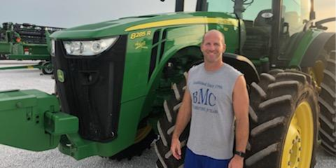 Klayton Finley in front of John Deere tractor